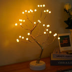 Bonsai Tree 36-LED lamp creating warm ambient lighting on a bedside table