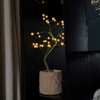 Bonsai Tree 36-LED lamp glowing beside a window in a dark room