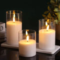 Three glass flameless LED candles glowing in a warm interior setting
