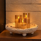 Glass flameless LED candle set glowing on a wooden side table